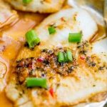 Spicy garlic soy baked flounder fillets with green onions, prepared in a foil pan.