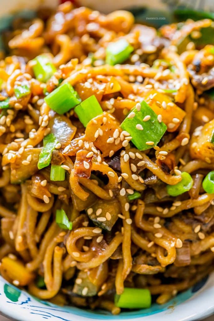 tahini noodles with stir fry vegetables and sesame seeds in a bowl 