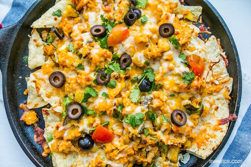 tortilla chips covered in chicken, cheese, olives, tomatoes, and cilantro.
