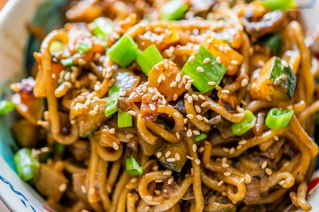 tahini noodles covered in sesame seeds in a bowl 