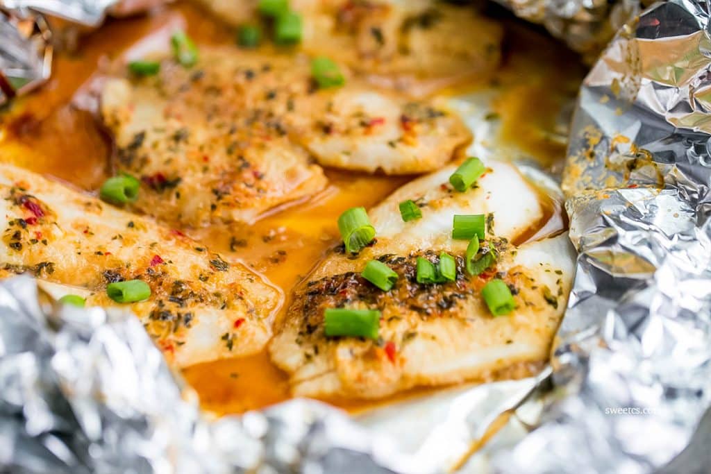 flounder in a foil pouch with spices and sauce and green onions