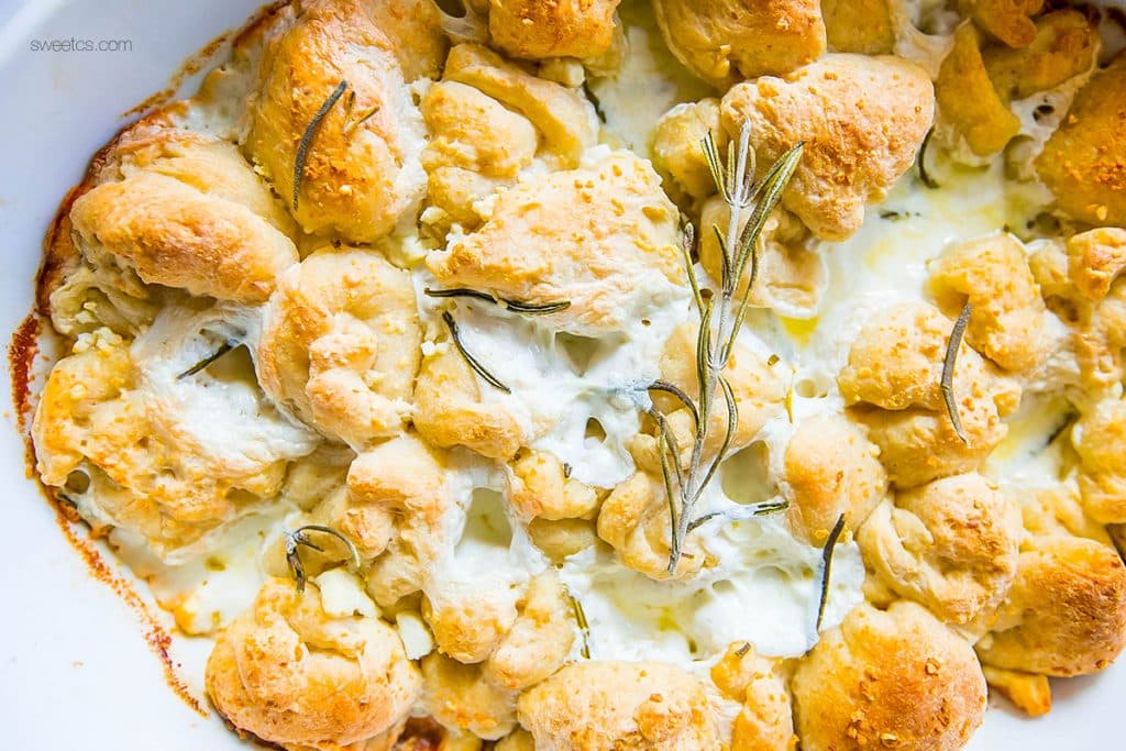 bread in a casserole dish with cheese and rosemary