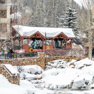 A group of people are walking down a snow-covered street in Beaver Creek, Colorado.