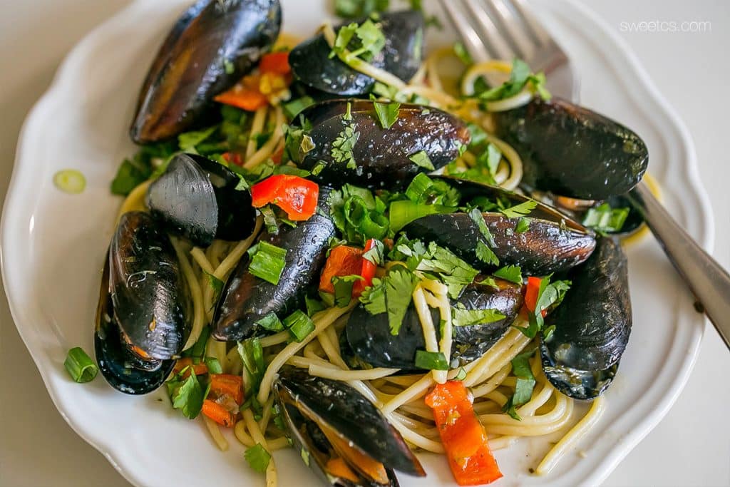 mussels, pepper, noodles, green onions, with parsley on them