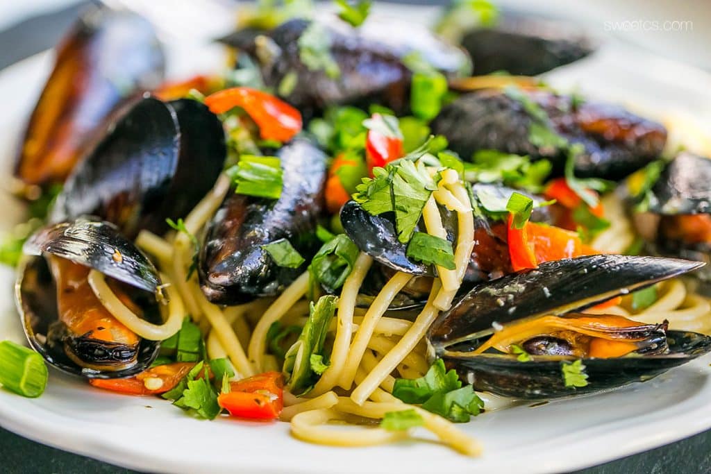 mussels, pepper, noodles, green onions, with parsley on them