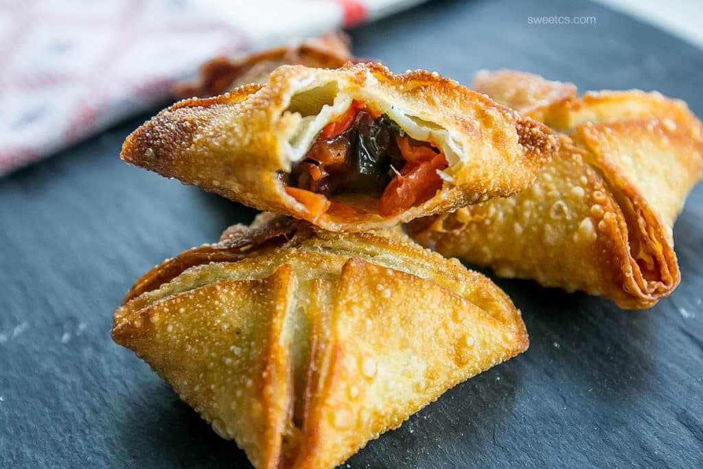 crispy samosas with red chutney on them