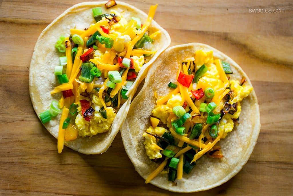 These spicy breakfast tacos are fileld with roasted poblano and bell peppers, caramelized onions, and cheesy scrambled eggs - wake up to a fiesta!