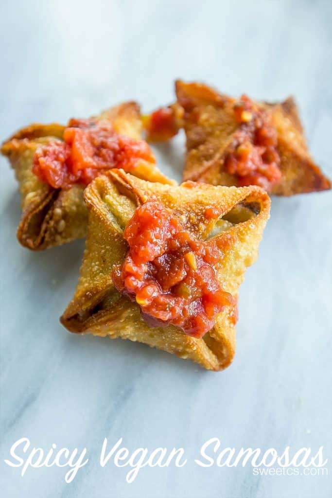 crispy samosas with red chutney on them