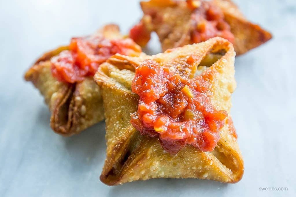 crispy samosas with red chutney on them