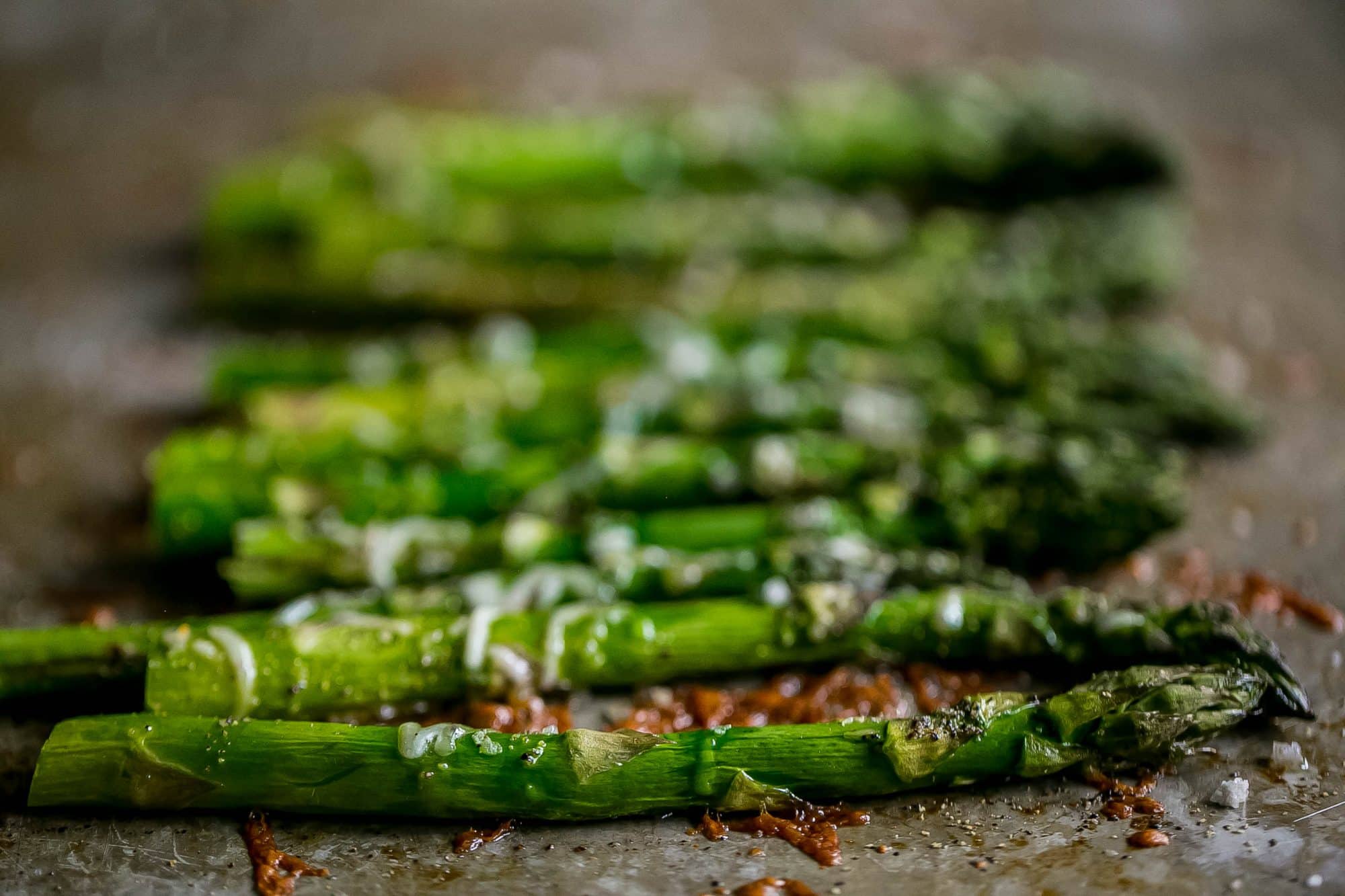 asparagus roasted on baking sheet with melted parmesan