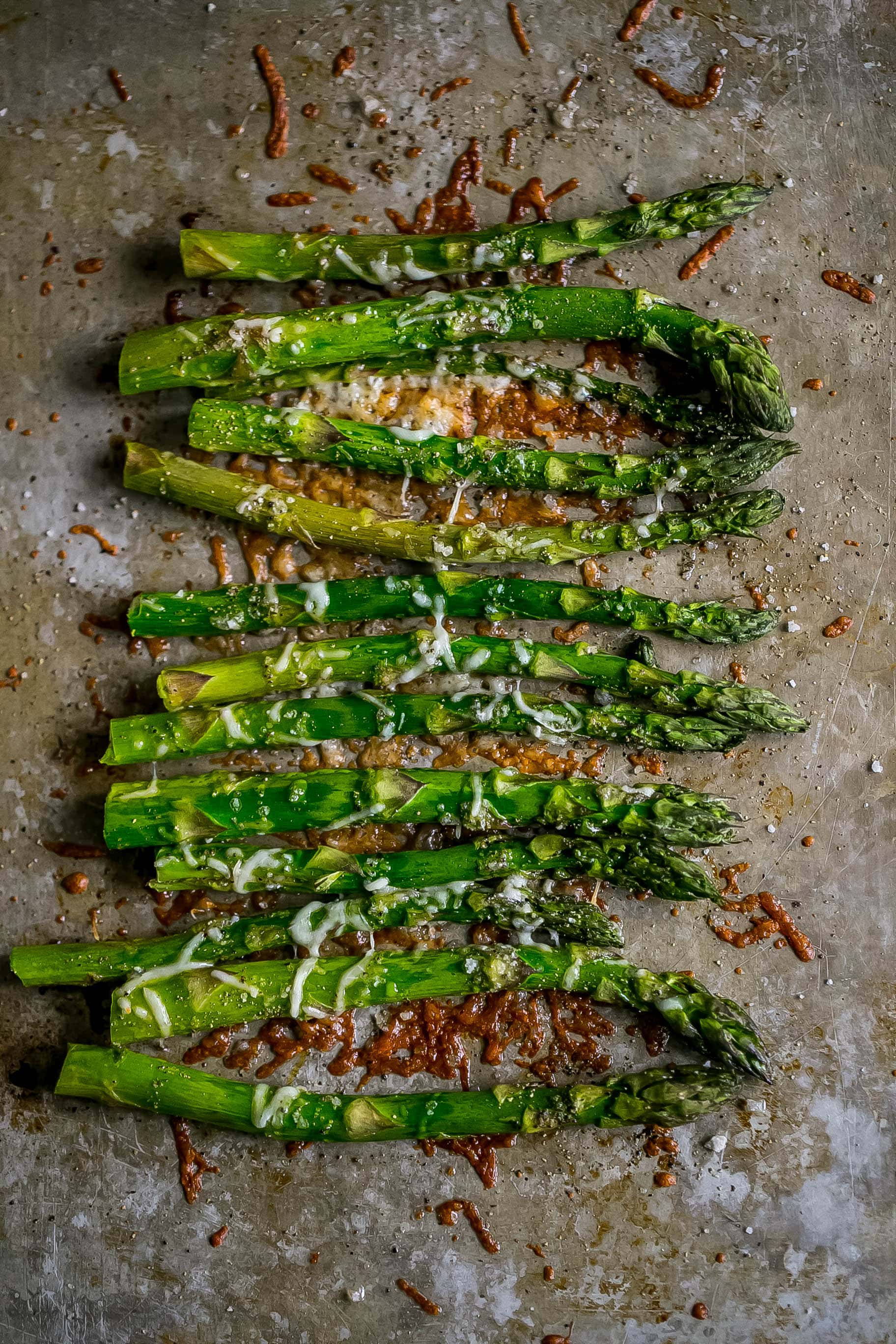 roasted asparagus on a baking sheet with parmesan