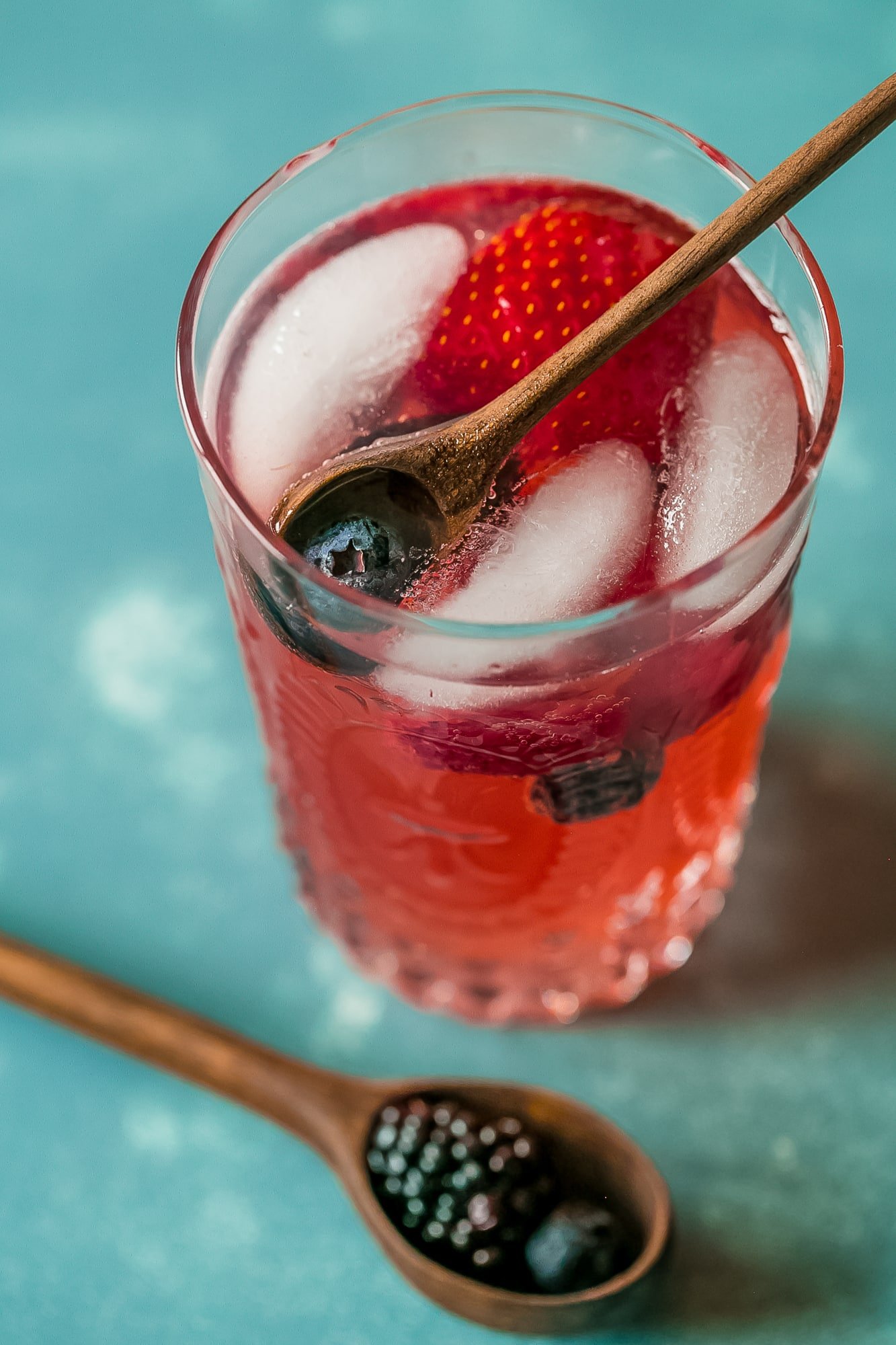 red lemonade with strawberries and blackberries in it