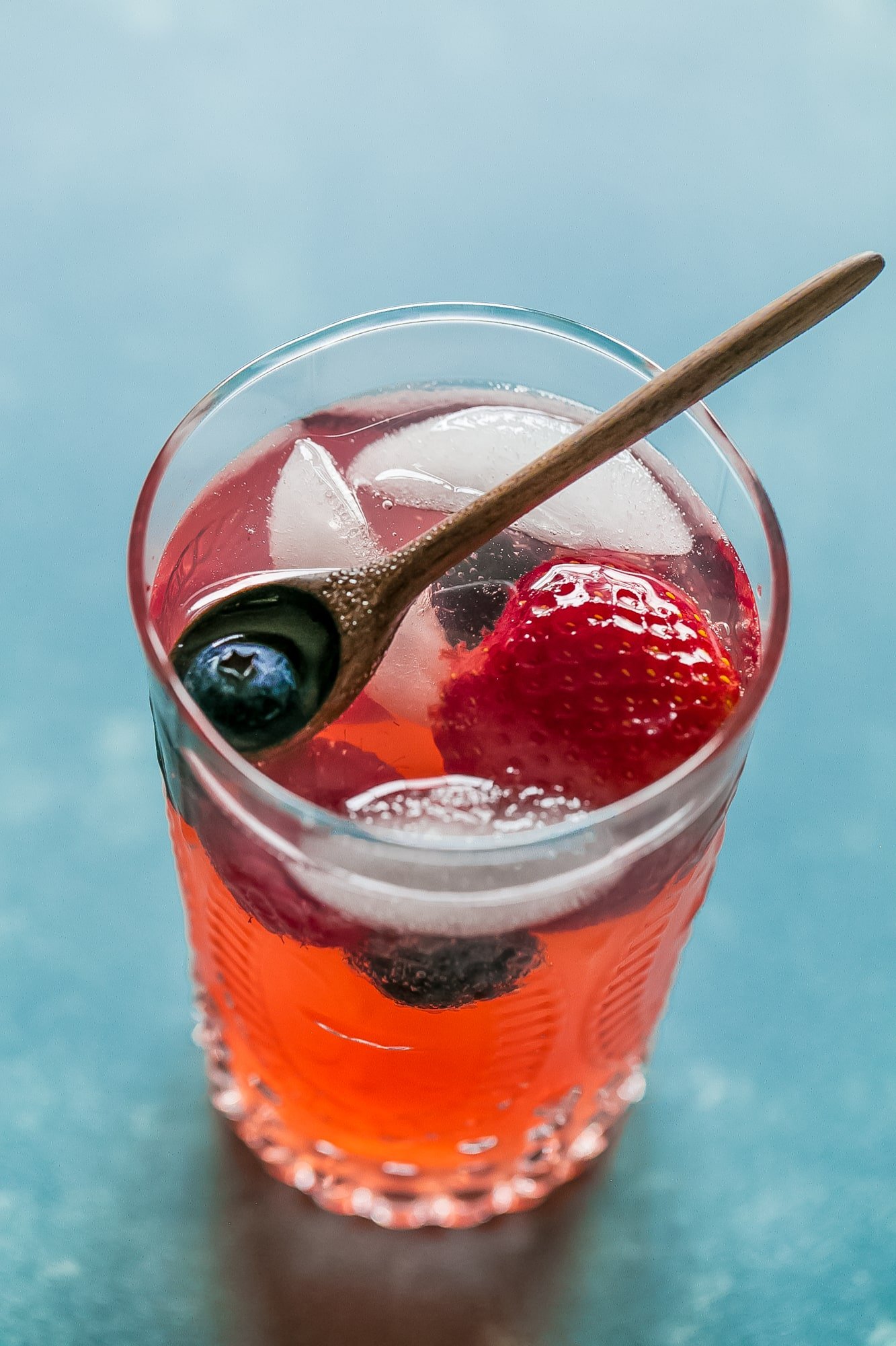 red lemonade with strawberries and blackberries in it