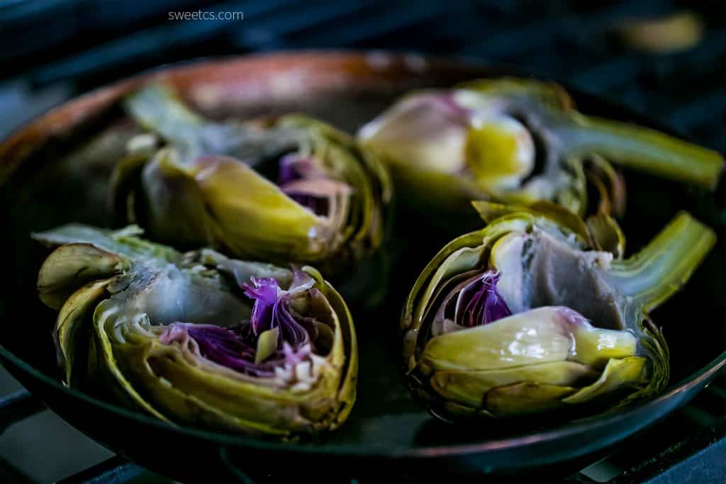 charred artichokes with butter on them