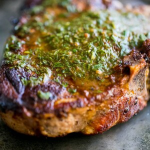 Carrot top chimichurri drizzled over chambourcin on a plate.