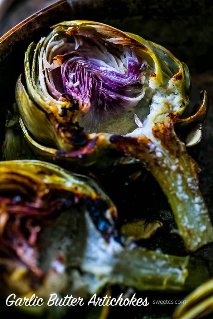 charred artichokes with butter on them