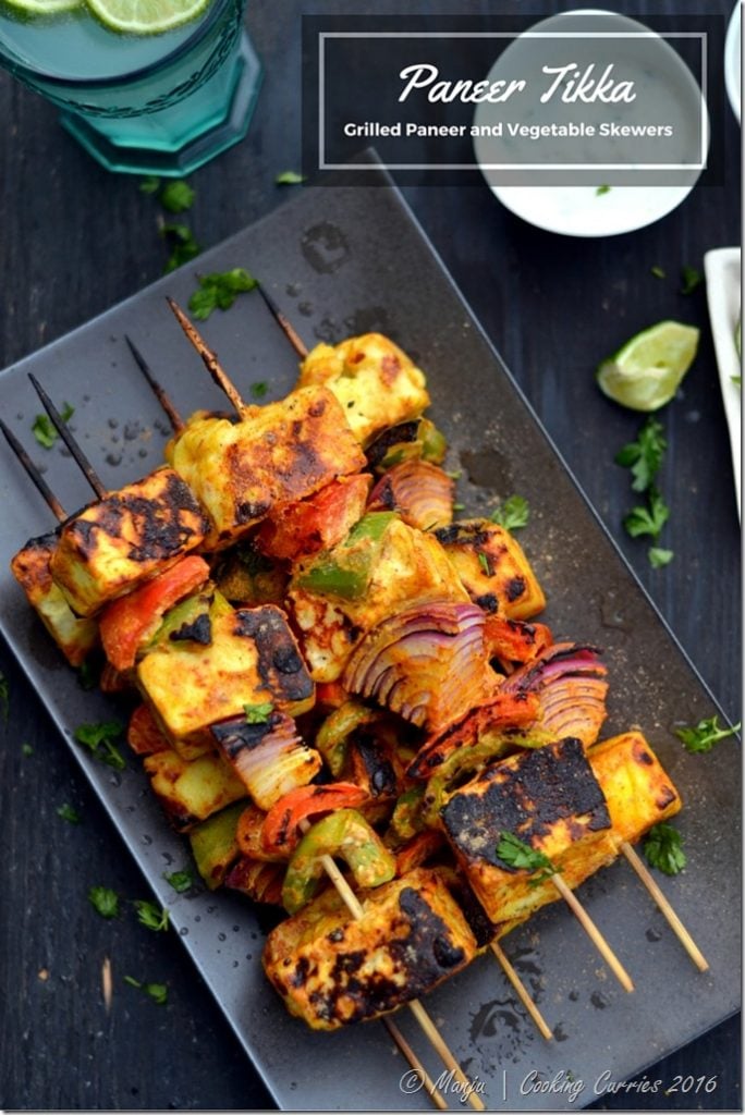 vegetables and paneer on skewers grilled with lime and cilantro on the side