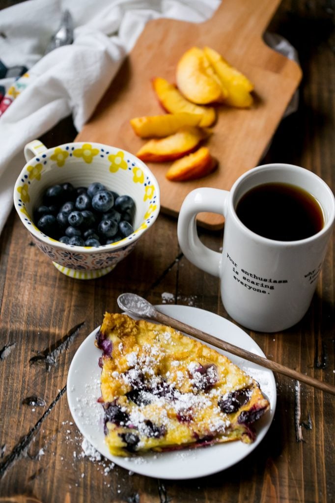 pancake in a cash iron skillet with blueberries and peaches