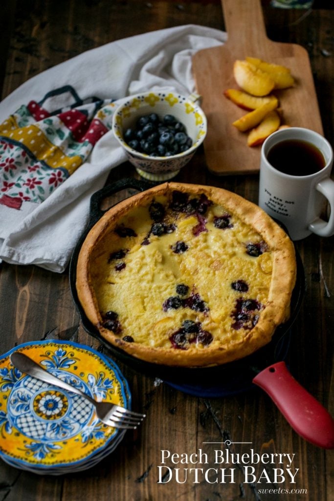 pancake in a cash iron skillet with blueberries and peaches