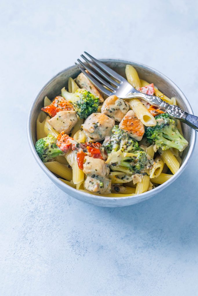 Creamy chicken and broccoli alfredo in  bowl with a fork