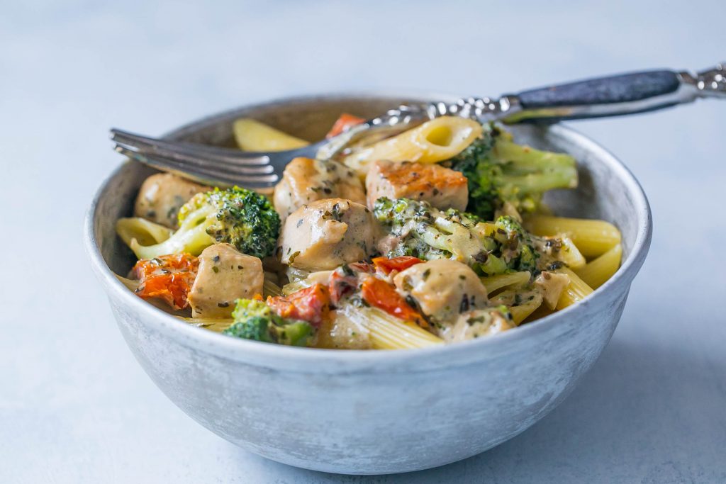 Creamy chicken and broccoli alfredo in  bowl with a fork