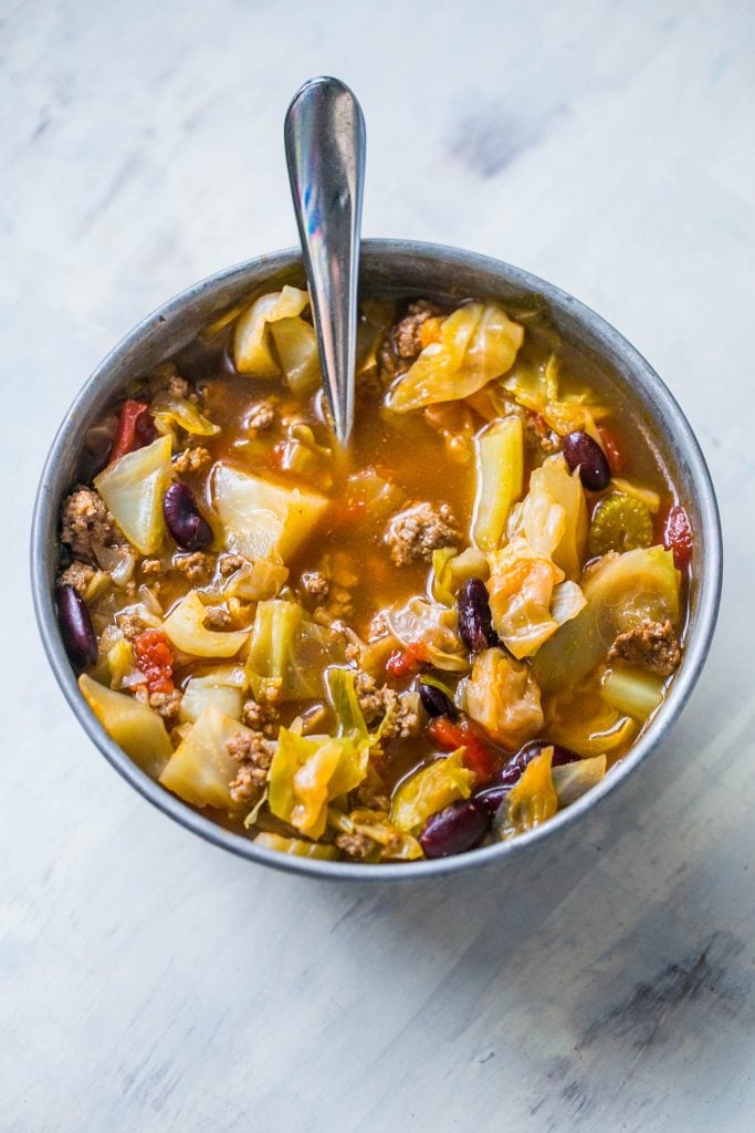 Picture of hamburger cabbage soup in a metal bowl with a spoon 