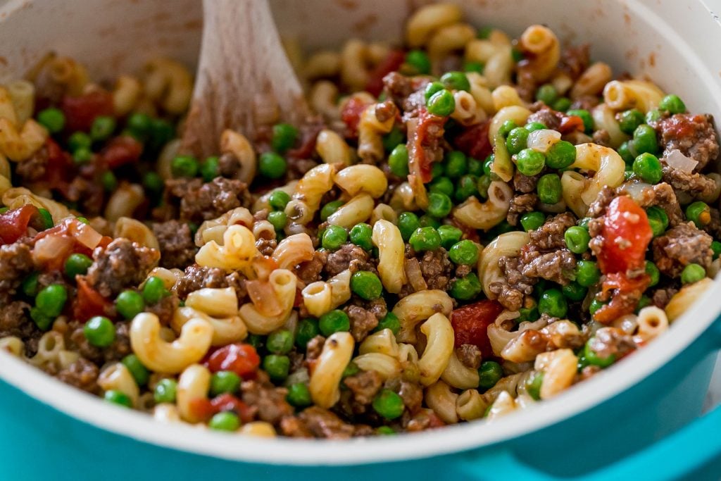 noodles with peas, beef, and tomatoes in it