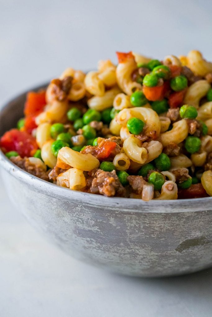 noodles with peas, beef, and tomatoes in it