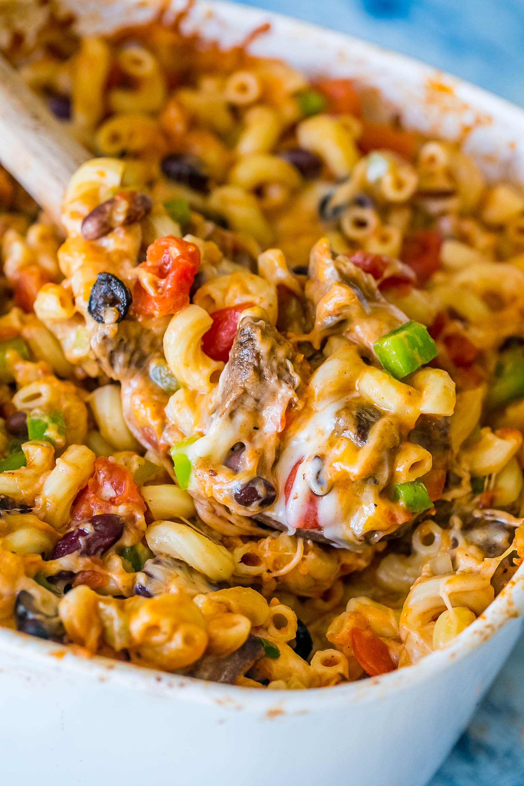 casserole dish with bell peppers, cheese, beans, diced tomatoes, pasta, and steak