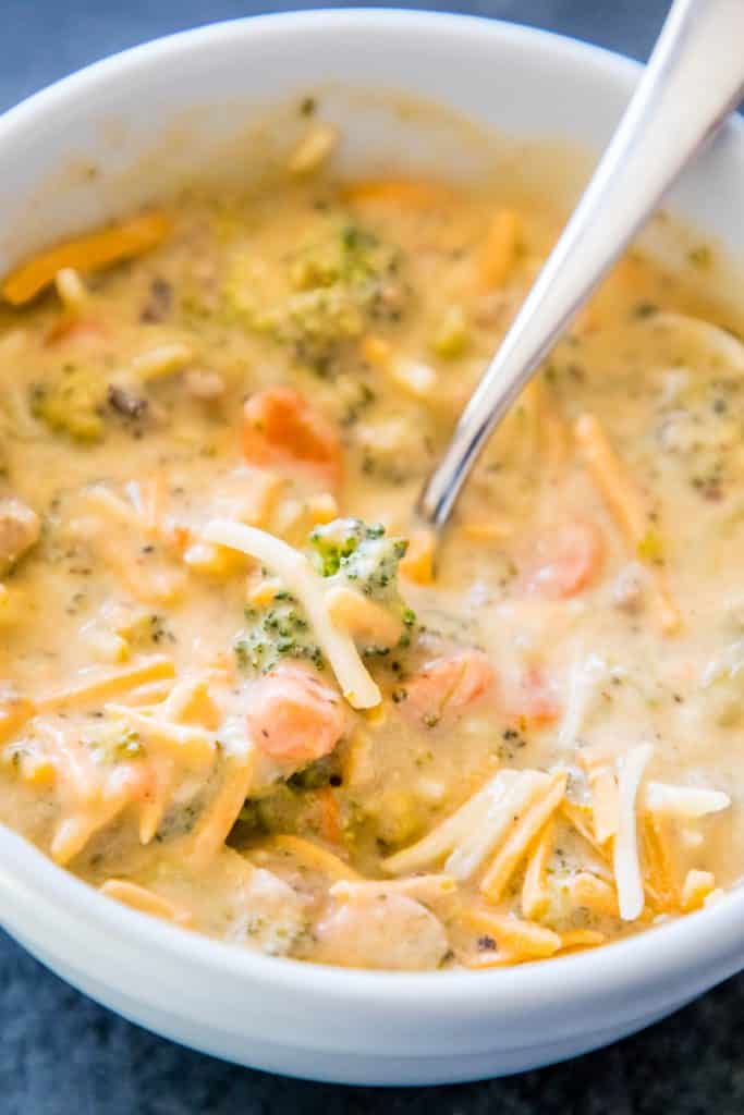 picture of creamy cheesy and broccoli soup with a spoon in it. 
