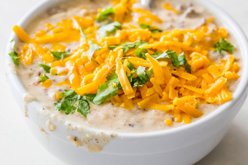 creamy soup with cilantro and cheese melted on it