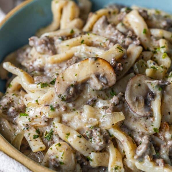 Close-up of Creamy Beef Stroganoff Fettuccine with sliced mushrooms, ground beef, onions, and herbs in a blue bowl.