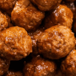 Close-up view of several Whiskey BBQ Meatballs coated in a rich brown sauce.