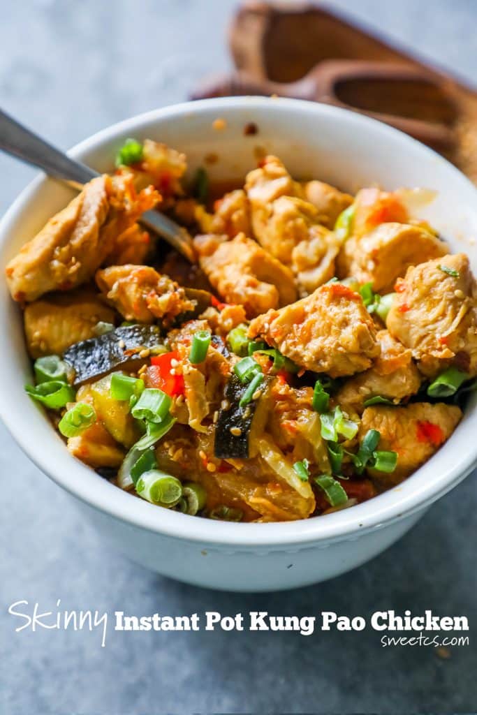 picture of chicken kung pao with chicken and vegetables in a white bowl with a fork in it. 