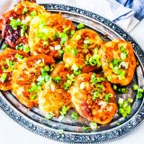 A plate of fried chicken with green onions atop, complemented by a classic irish potato pancake recipe.