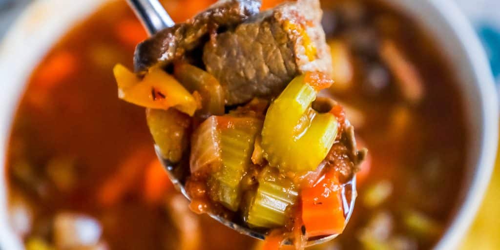 bowl of soup with beef, celery, carrots, and broth