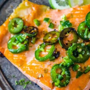 Honey-lime salmon with jalapenos served on a silver plate.