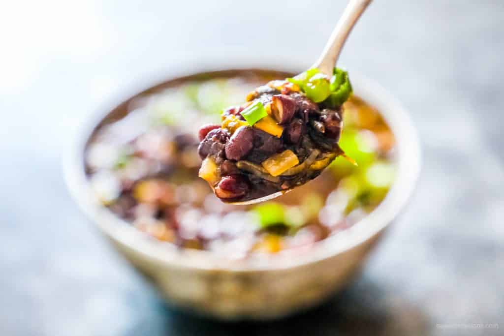 spoon with beans and green onions on it