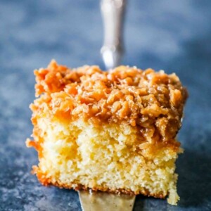 A piece of Danish Dream Cake with caramel and coconut on a silver fork.