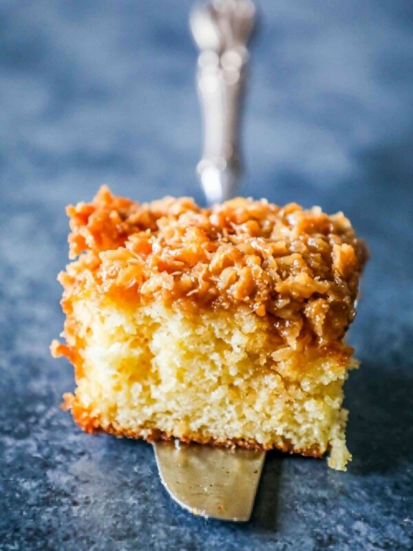 A piece of Danish Dream Cake with caramel and coconut on a silver fork.