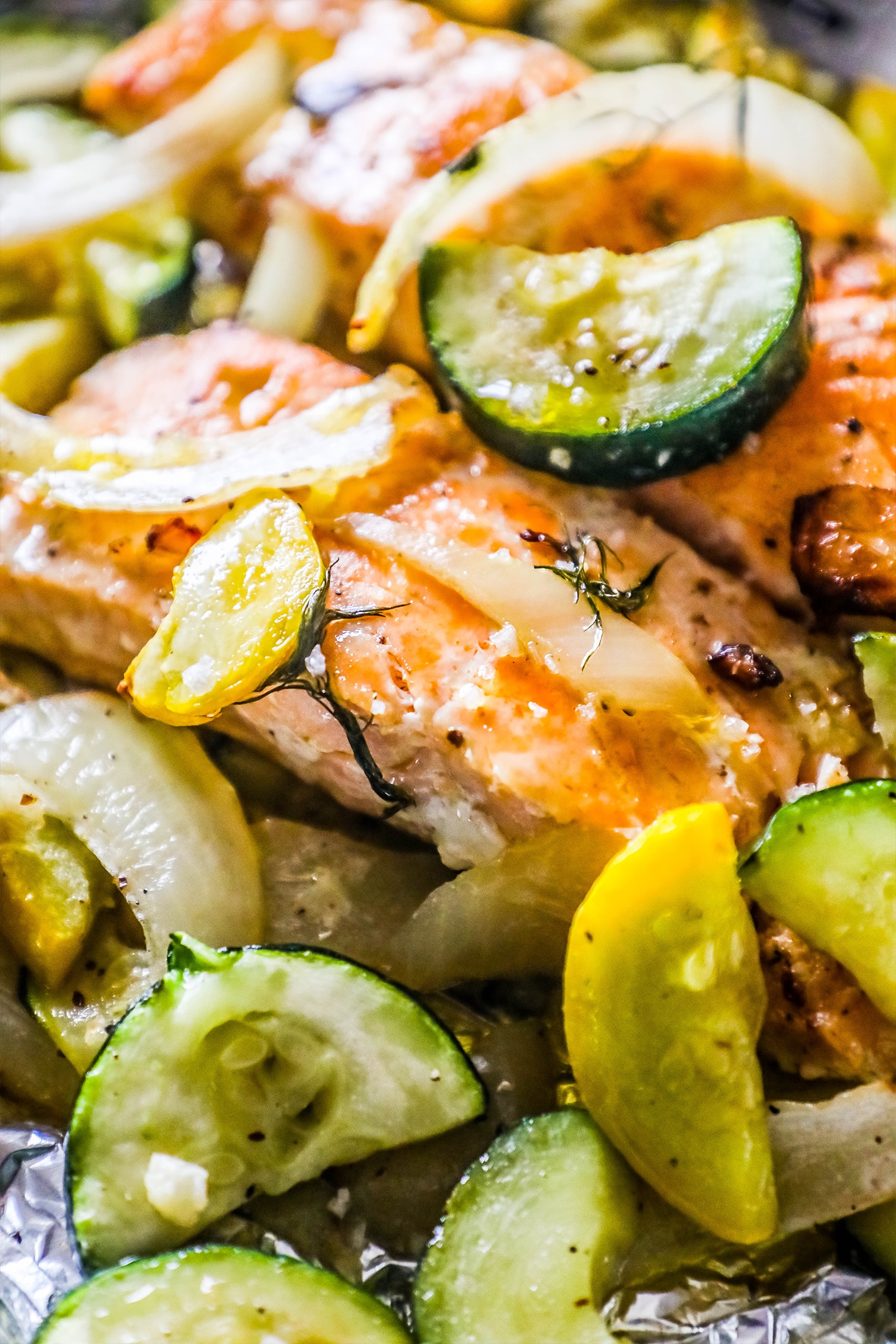 salmon with dill surrounded by zucchini, squash, and onion