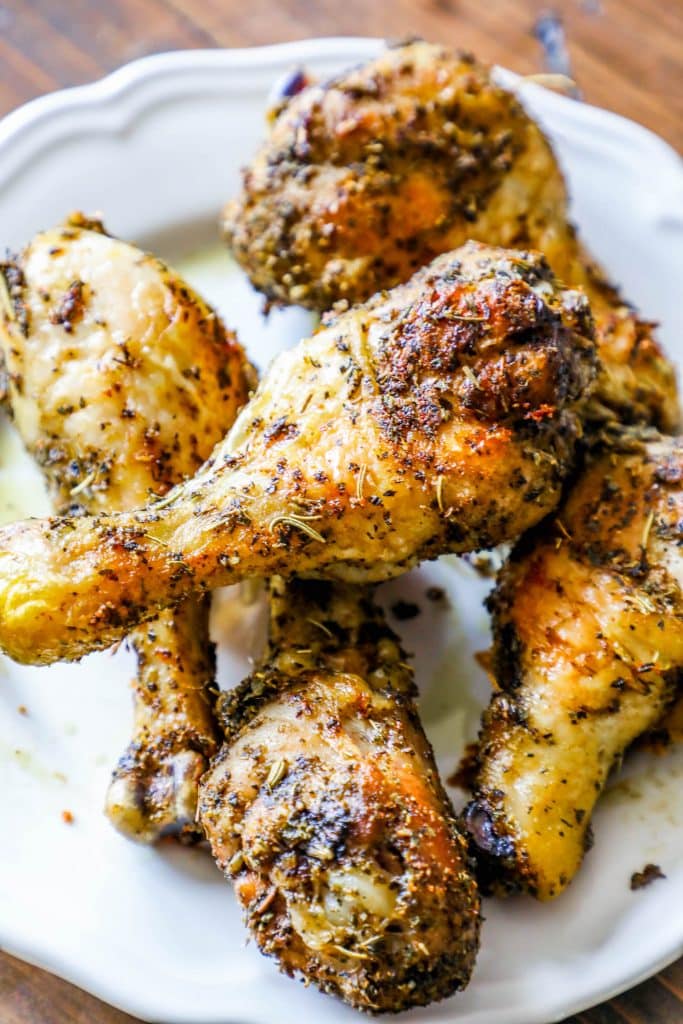 crispy chicken drumsticks with rosemary and herbs all over them