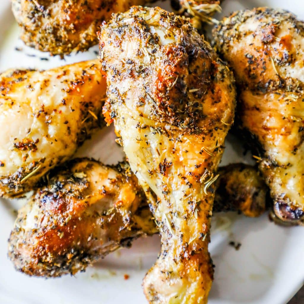 crispy chicken drumsticks with rosemary and herbs all over them
