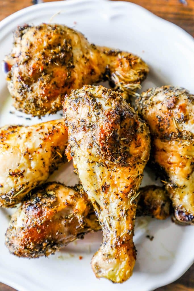 crispy chicken drumsticks with rosemary and herbs all over them