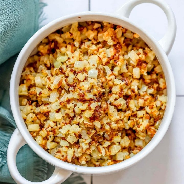 Easy keto cauliflower rice recipe served in a white bowl on a tile floor.