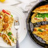 Chicken breasts in a skillet with spinach and lemon, resembling chicken florentine stuffed with spinach.