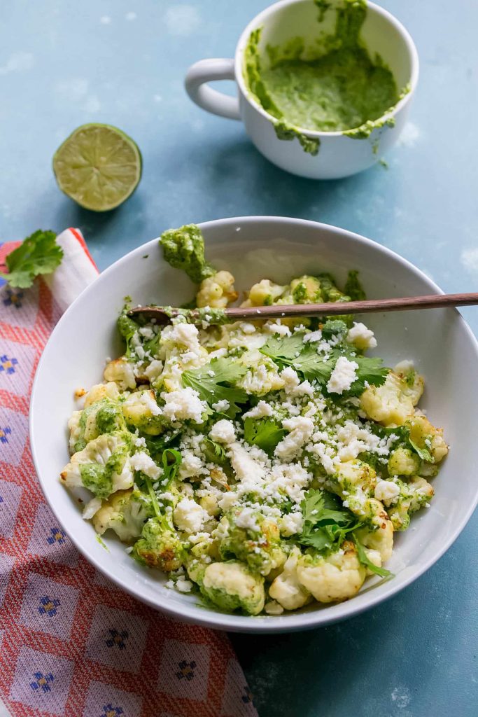 cauliflower covered in pesto and cheese and cilantro