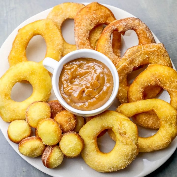 Fast and easy homemade donuts made with canned biscuits, topped with peanut butter, served on a plate.