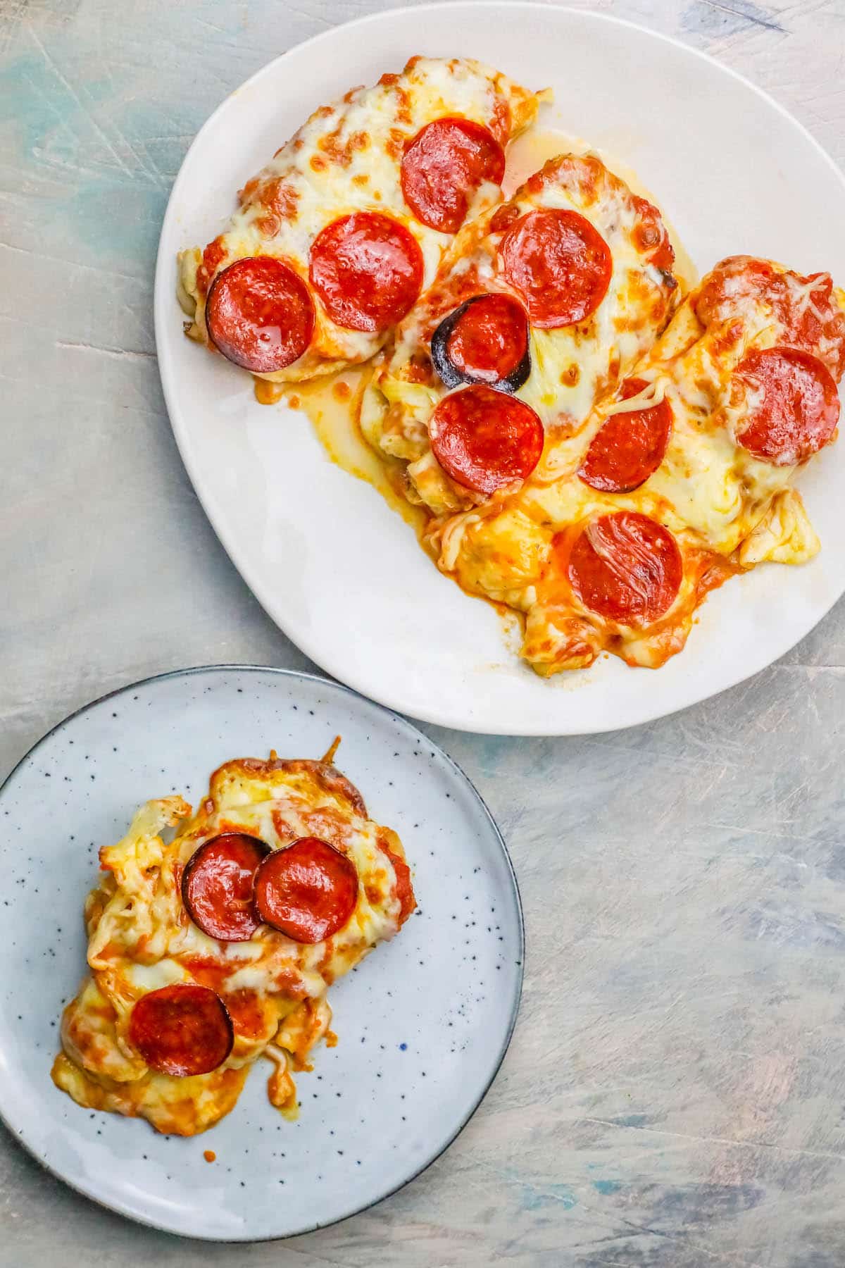 chicken smothered in cheese and pepperonis on a plate