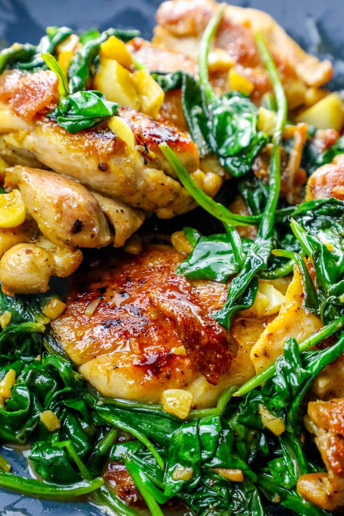 pan with chicken, bacon and spinach in it